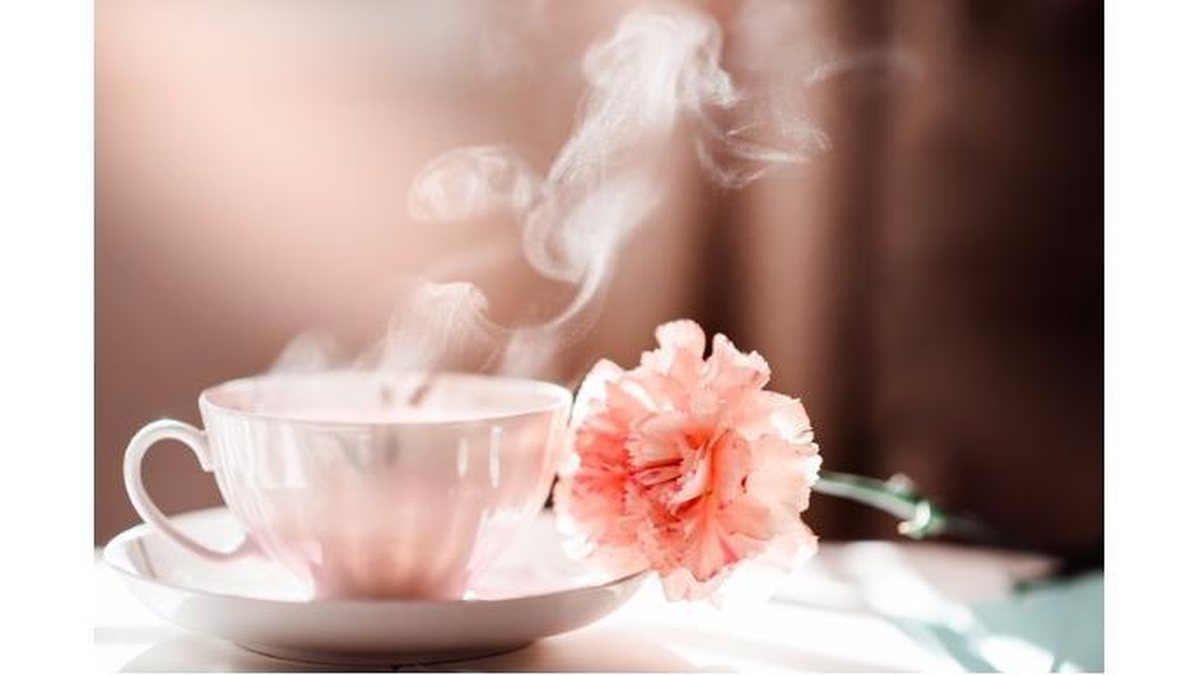 morning-coffee-tea-cup-with-steam-and-carnation-flower-picture-id617597890