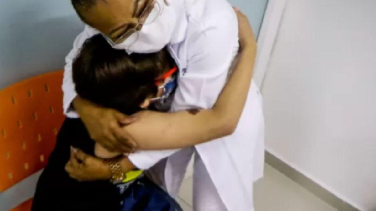 Criança abraça enfermeira após se vacinar - Reprodução / Aloiso Maurício / Foto Arena / Estadão
