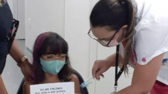 Menina faz homenagem à mãe enquanto recebe vacina contra a Covid-19 - Reprodução / TV Globo
