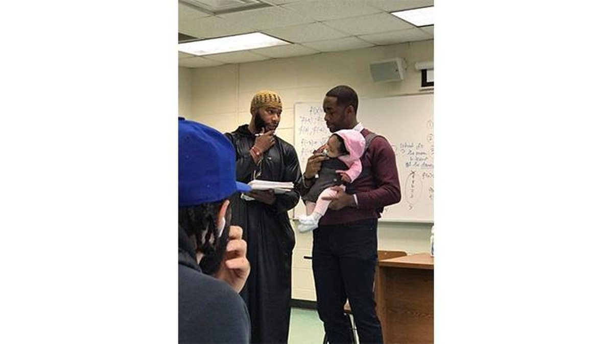 Professor explica a matéria enquanto ajuda aluno a tomar conta de filha (Foto: Reprodução/Instagram 