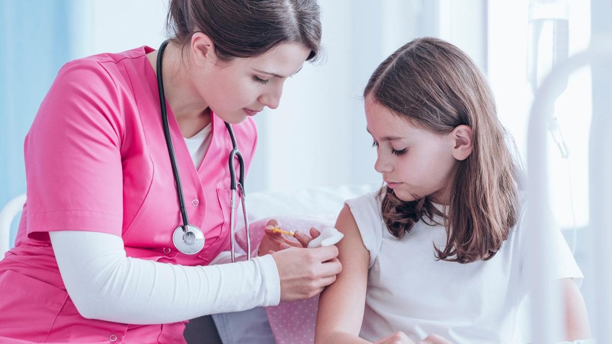 Menina sendo vacinada por enfermeira - Getty Images