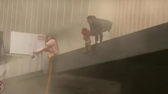 Imagem Vídeo mostra momento em que mãe joga bebê de prédio em chamas para tentar salvá-lo