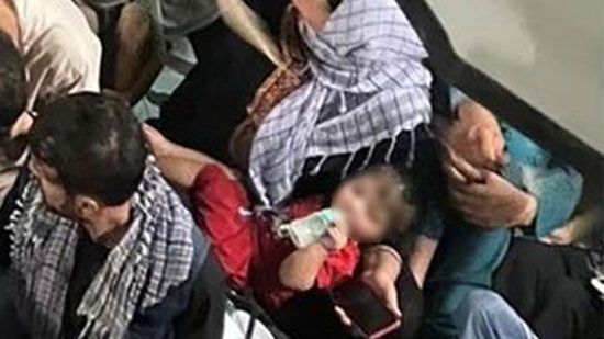 Imagem Foto interna de avião americano resgatando 600 afegãos mostra bebê com mamadeira no colo da mãe