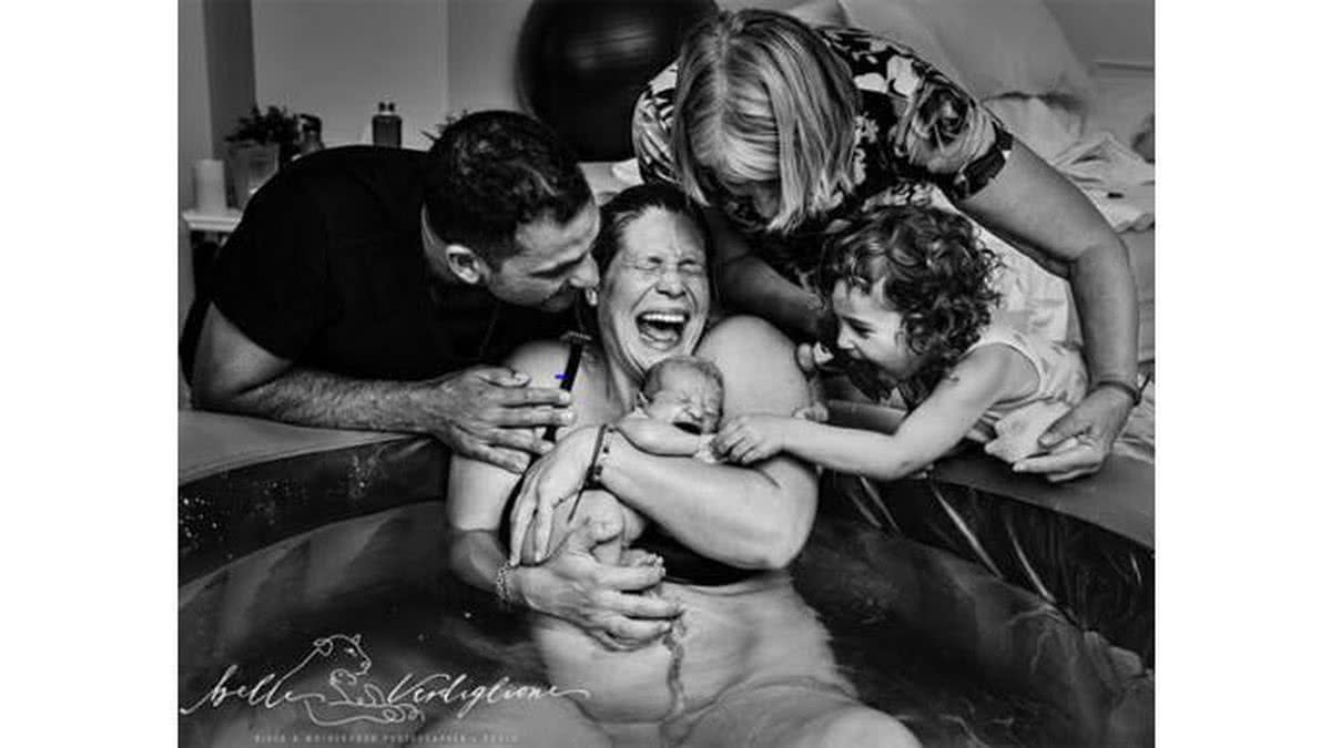 Foto campeã geral mostra família reunida enquanto mãe dá a luz na banheira (Foto Reprodução/International Association of Professional Birth Photographers)