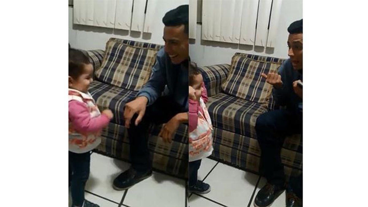 A menina tenta falar com o pai em linguagem de sinais - Reprodução/ Facebook
