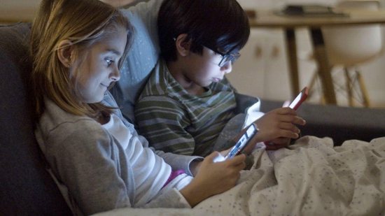 Menino usando celular - é necessário supervisionar as ações do seu filho na internet