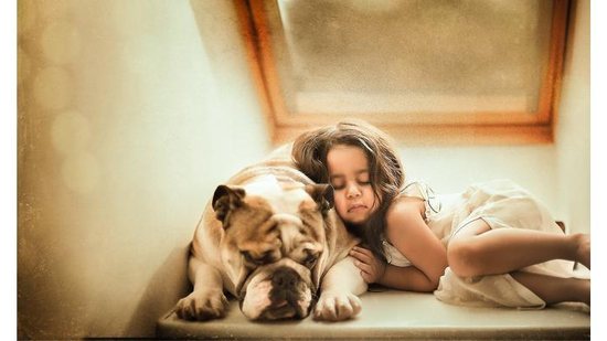 Imagem Fotógrafa registra amizade entre sua filha e cachorro da família
