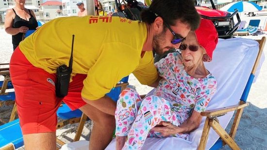 Salva-vidas ajudando senhora de 95 anos na praia - Reprodução/Razões para Acreditar