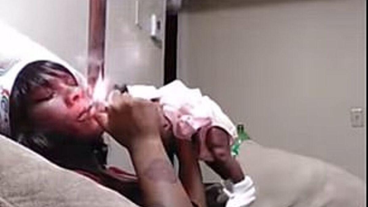 Ela fumou perto do rosto do bebê e levantou a criança várias vezes apenas com um braço - reprodução / Daily Mail