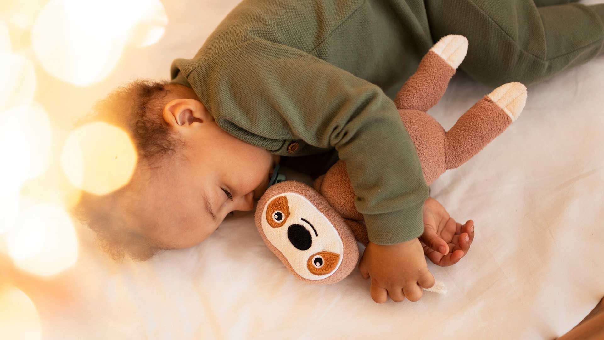 Criança dormindo abraçada a uma pelúcia