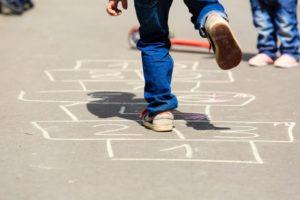 kids-playing-hopscotch-on-playground-outdoors-picture-id512047790