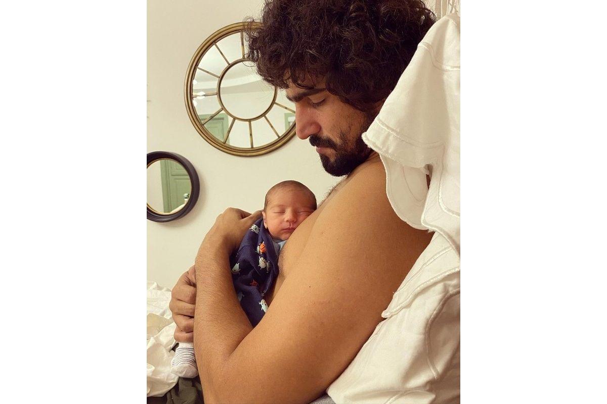 Renato Góes segurando o filho recém-nascido