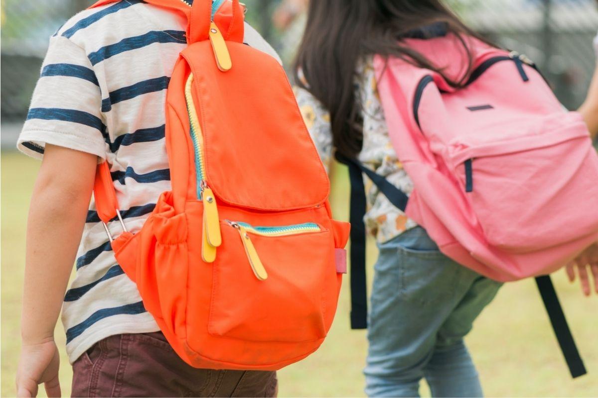Crianças usando mochilas escolares