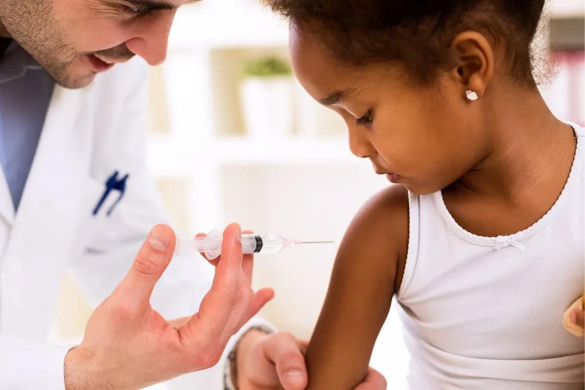 Médico aplicando vacina na criança
