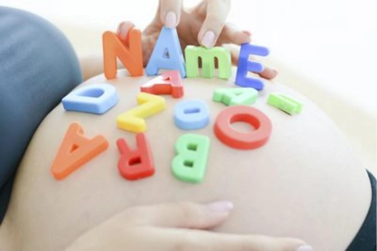 Letras formam a palavra "name" em cima da barriga de grávida