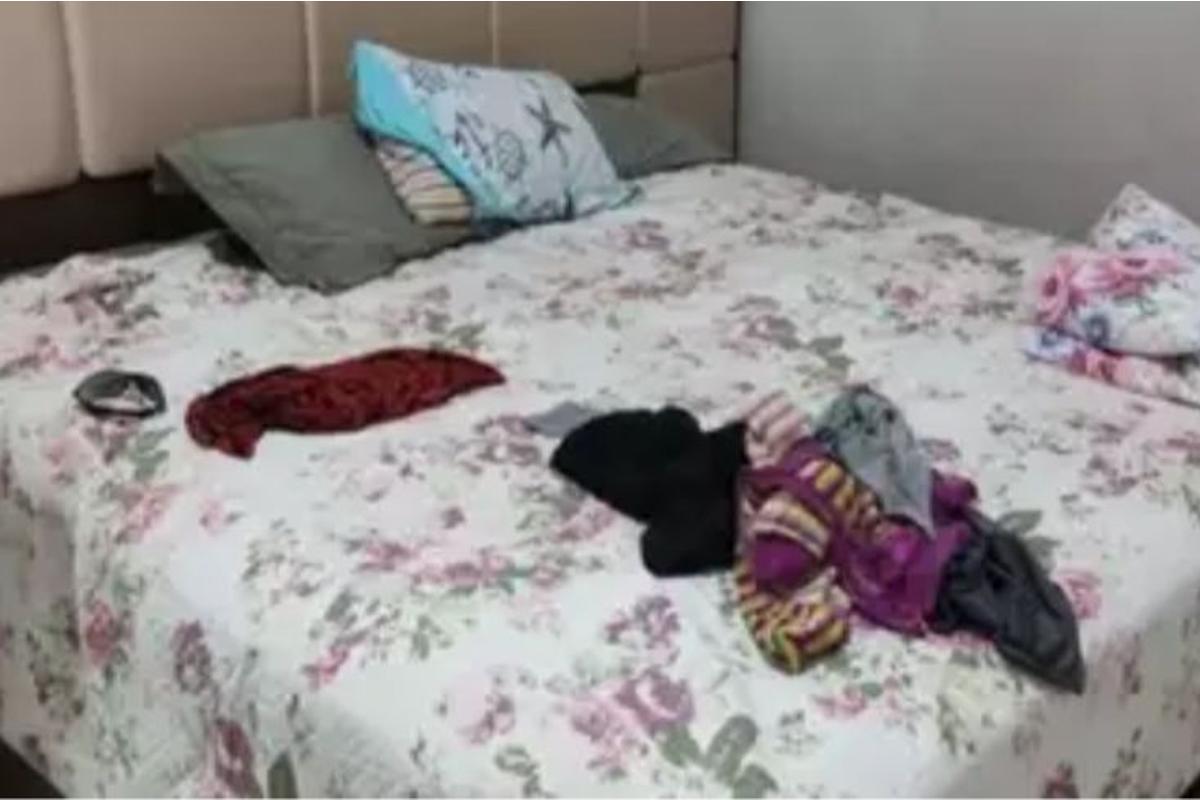 A menina estava dormindo atrás dos travesseiros na cama da mãe