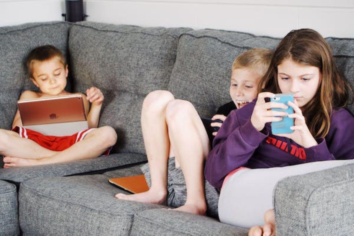 Crianças mexendo em aparelhos eletrônicos como celulares e tablets
