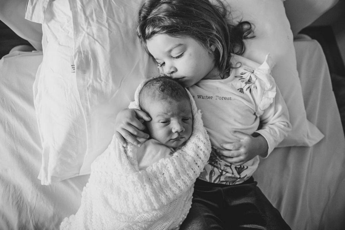 Filha de Chay Suede segurando o irmão recém-nascido
