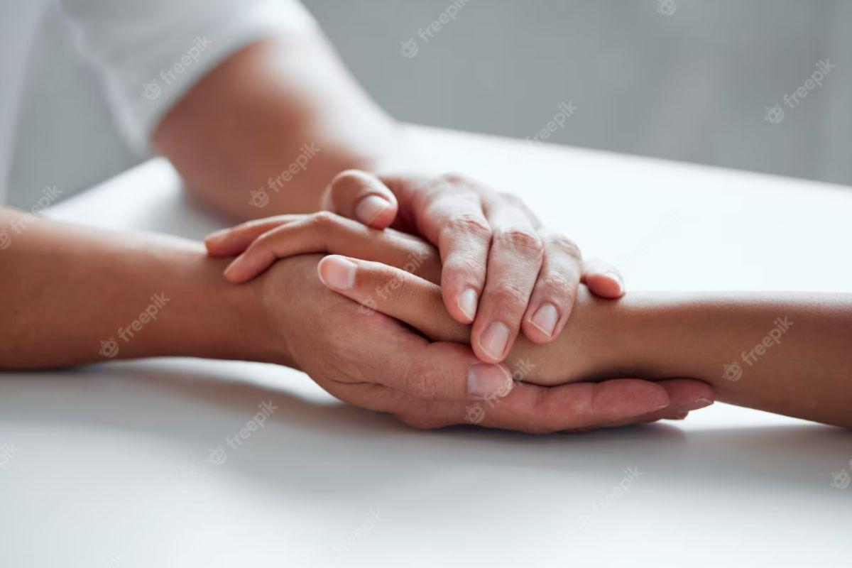 Mão masculina segurando mão feminina, mão masculina dando apoio para mão feminina, mãos dadas de suporte